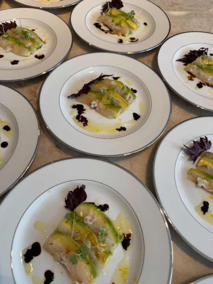 Vis carpaccio met avocado, micro greens en olijfolie — gedresseerd op wit bord