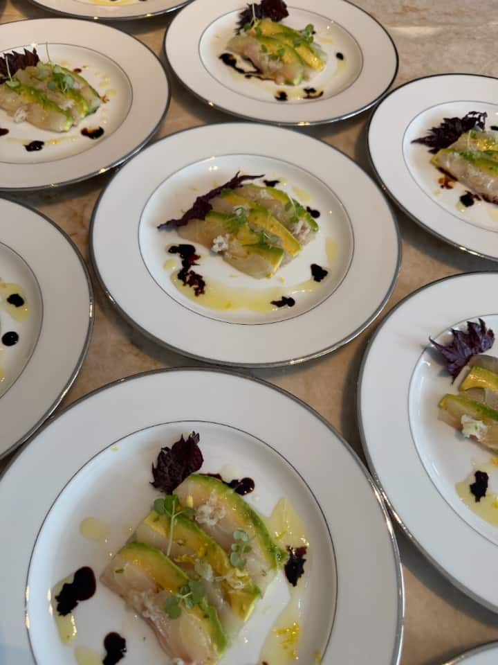 Vis carpaccio met avocado, micro greens en olijfolie — gedresseerd op wit bord