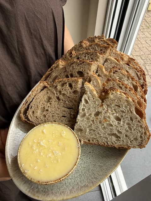Ambachtelijk brood met boter op keramieken bord