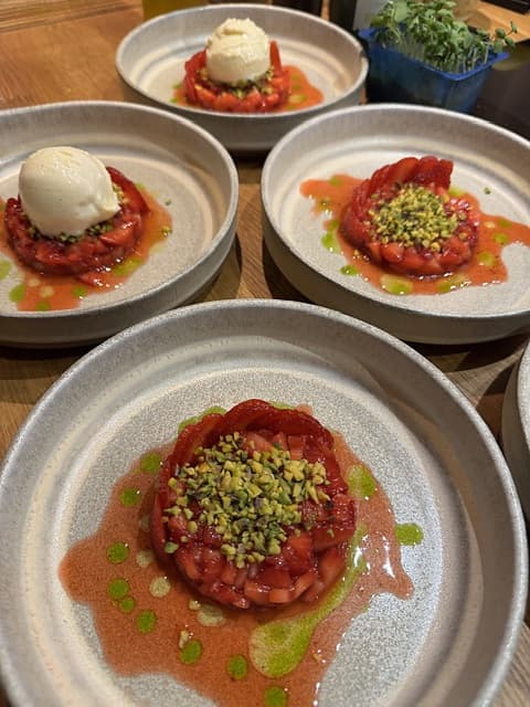 Dessert met aardbei, vanille en pistache op keramieken borden