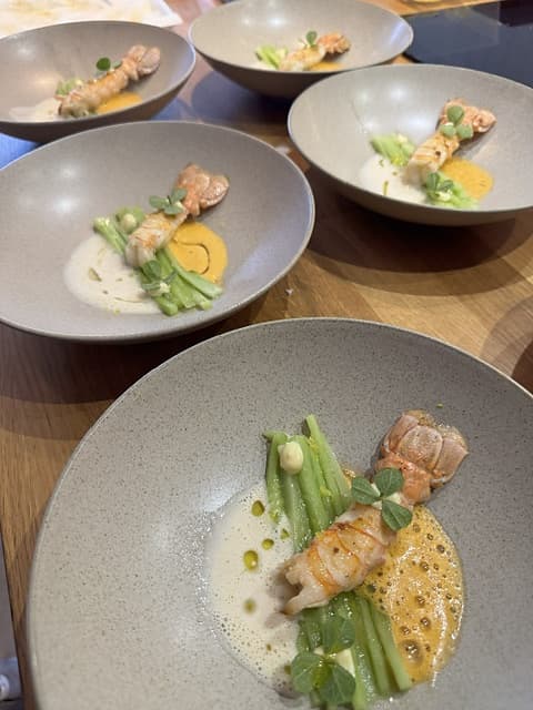 Langoustine met boontjes en schuimige saus in meerdere borden
